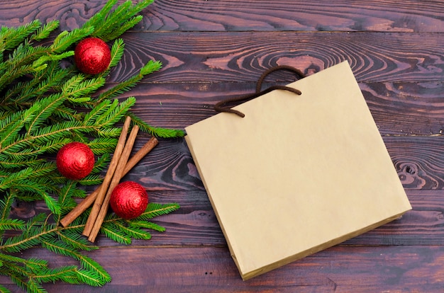 Flat lay of a Christmas tree with red  balls, decorations, and paper bag. top view