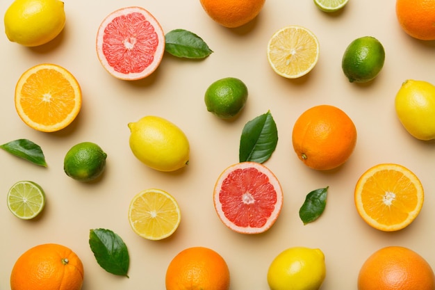 Flat lay of citrus fruits like lime orange and lemon with lemon tree leaves on light colored background Space for text healthy concept Top view