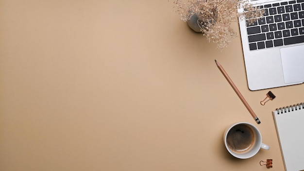 Photo flat lay comfortable workspace with laptop computer notebook and coffee cup on beige background