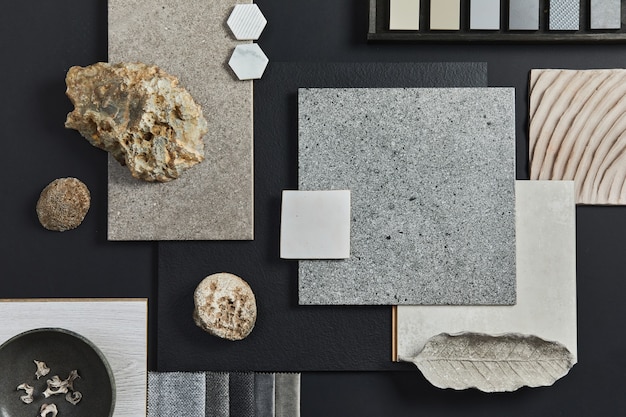 Flat lay composition of creative black architect moodboard with samples of building, textile and natural materials and personal accessories. Top view, black backgroung, template.