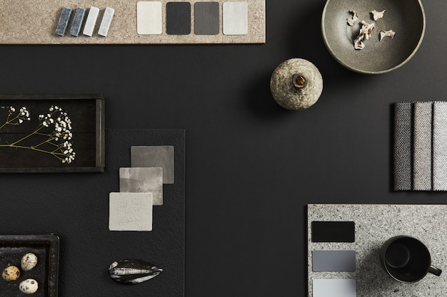 Composizione piatta della moodboard creativa dell'architetto nero con campioni di materiali edili, tessili e naturali e accessori personali. vista dall'alto, sfondo nero, modello.