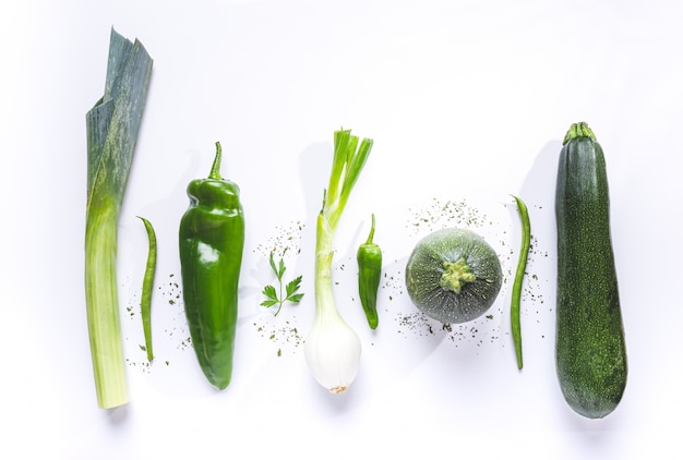 Flat lay composition of green vegetables on white background.