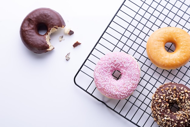 Flat lay composition of mixed donuts on white background.