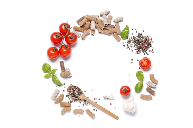 Flat lay composition of raw buckwheat pasta, cherry tomatoes, spices, basil, olive oil, garlic isolated on a white background.