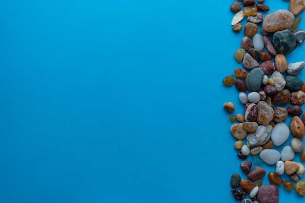 Flat lay composition sea pebbles on a blue background. space for text