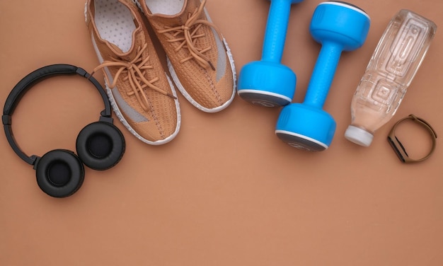 Flat lay composition sports accessories on brown background. Ready for training. Copy space. Top view