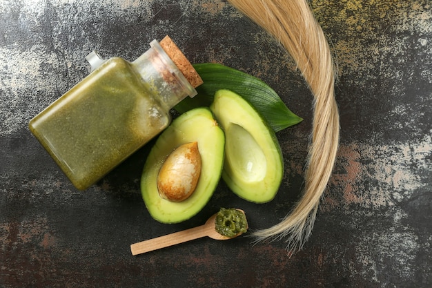Photo flat lay composition with avocado and natural cosmetic for hair on grunge