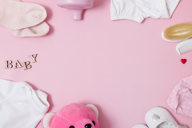 Фото Плоская композиция с детскими аксессуарами и игрушками на цветной розовой поверхности