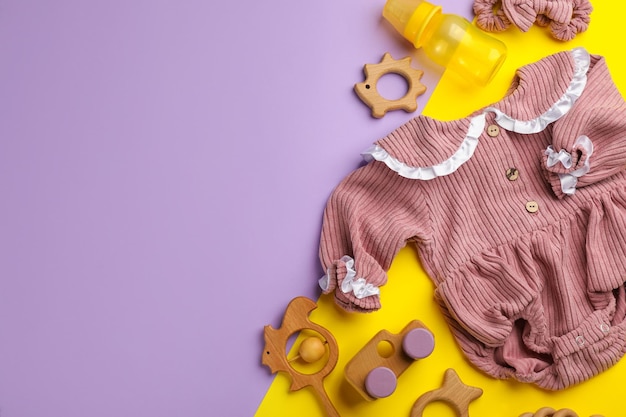 Photo flat lay composition with baby clothes and accessories on color background space for text