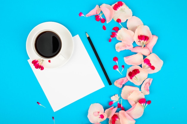 Flat lay composition with beautiful flowers and clean page, cup of coffee. Content plan concept.