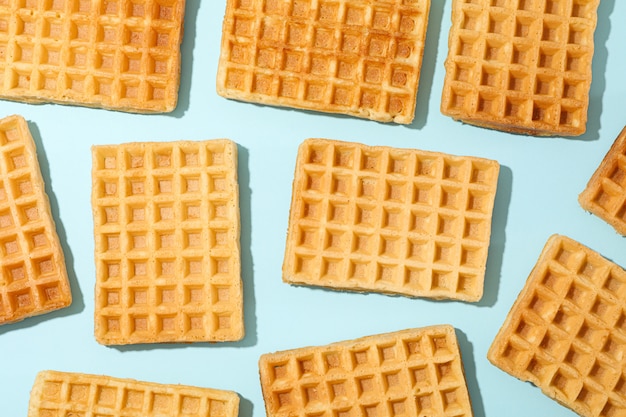 Flat lay composition with belgian waffles on color table