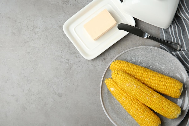 Flat lay composition with boiled corn cobs on light grey table Space for text