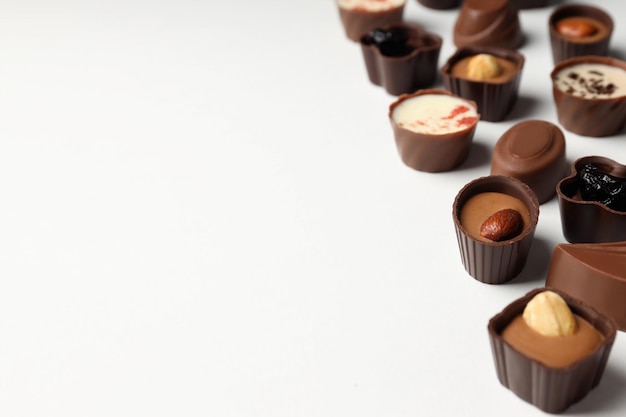 Flat lay composition with chocolate candies on white background