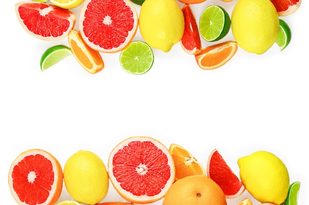 白い背景、コピースペースに柑橘系の果物、葉、花とフラットレイ構成。