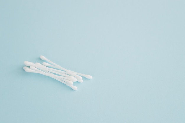 Flat lay composition with cotton swabs on blue background Top view ear sticks