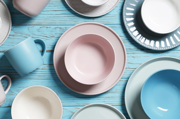 Flat lay composition with dishware and cutlery on blue table