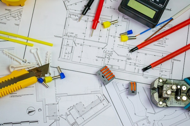 Flat lay composition with electrician's tools on house plan. Space for text.Selective focus.