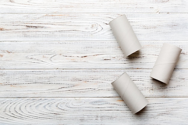 Flat lay composition with empty toilet paper rolls and space for text on color background Recyclable paper tube with metal plug end made of kraft paper or cardboard