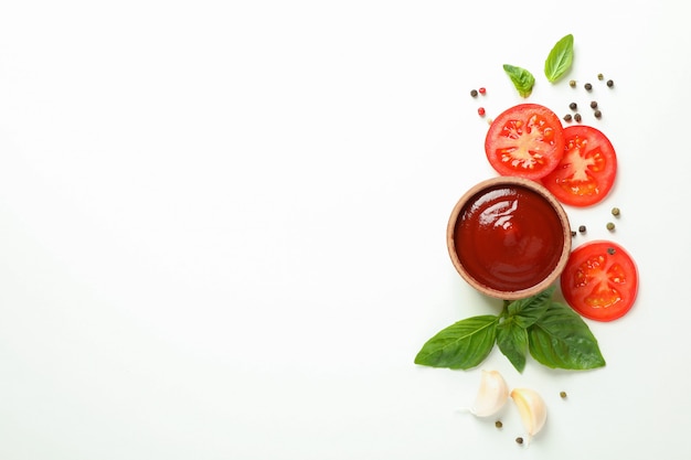 Плоская композиция с кусочками свежих помидоров черри, базиликом, перцем, чесноком и соусом. Спелые овощи