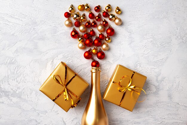 Flat lay composition with gold champagne bottle and Christmas balls