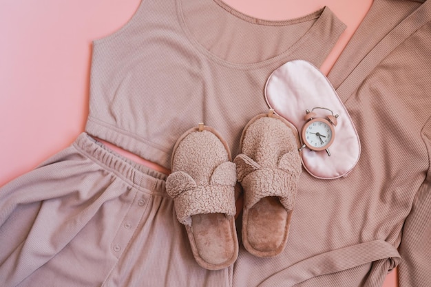 Photo flat lay composition with house slippers sleeping mask and pajamas on light background