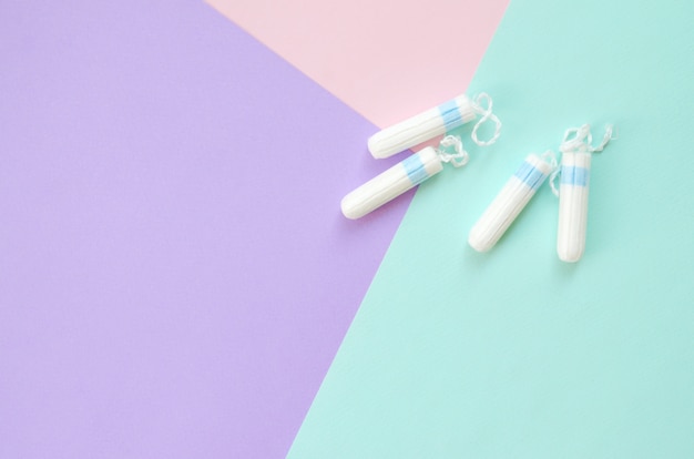 Flat lay composition with menstrual tampons on blue pink and lilac pastel background