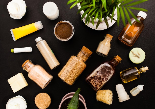 Flat lay composition with organic homemade cosmetic products on\
black background