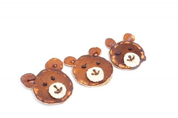 Flat lay composition with pancakes in form of bear isoleted on white background. Creative breakfast ideas for kids