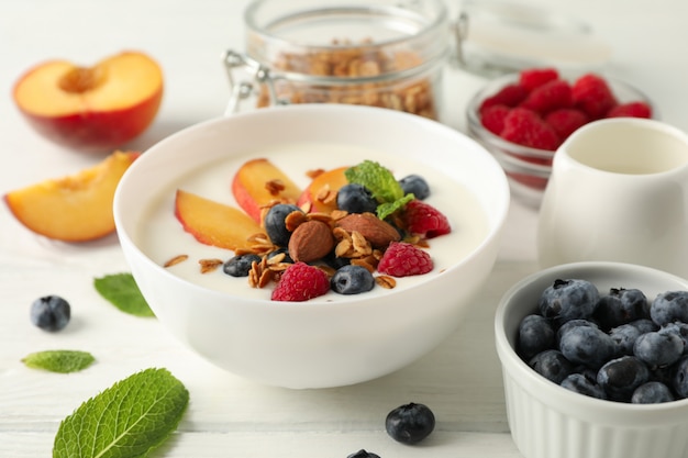 Flat lay composition with parfaits dessert and ingredients on white wooden background