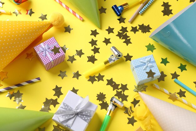 flat lay composition with party hats on yellow background