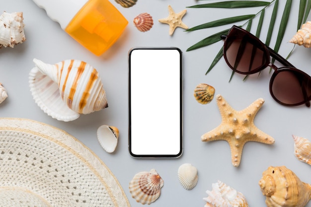 Flat lay composition with Phone and beach accessories on colored background Smartphone with blank screen mock up with copy space