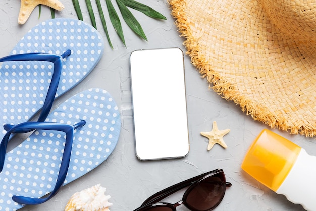 Photo flat lay composition with phone and beach accessories on colored background smartphone with blank screen mock up with copy space