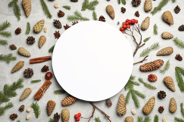 Flat lay composition with pinecones and blank card on light grey background space for text