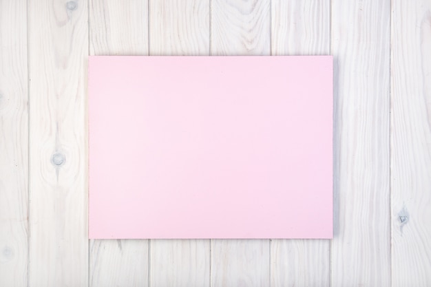 Flat lay composition with pink board on white wooden table