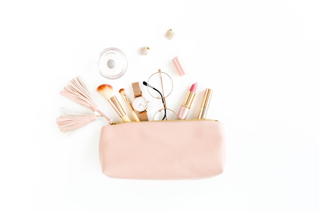 Flat lay composition with pink cosmetic bag with cosmetic makeup products isolated on white backgrou