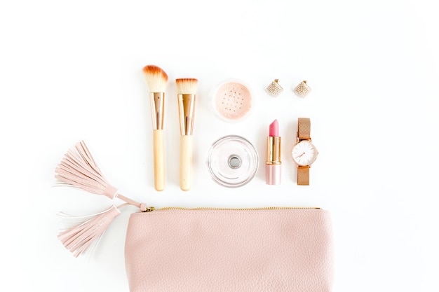 Flat lay composition with pink cosmetic bag with cosmetic makeup products isolated on white backgrou