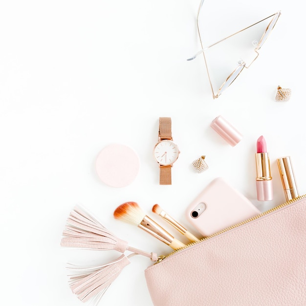 Photo flat lay composition with pink cosmetic bag with cosmetic makeup products isolated on white