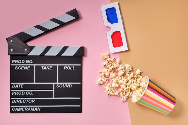 Flat lay composition with popcorn, 3d glasses and clapper board, space for text on color surface