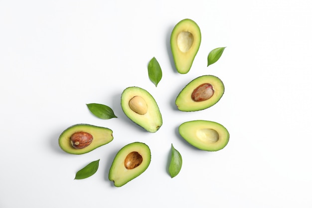 Flat lay composition with ripe avocados on white