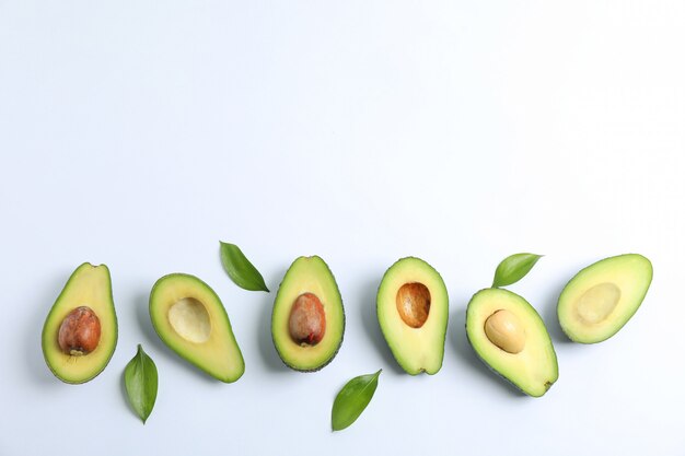 Flat lay composition with ripe avocados on white