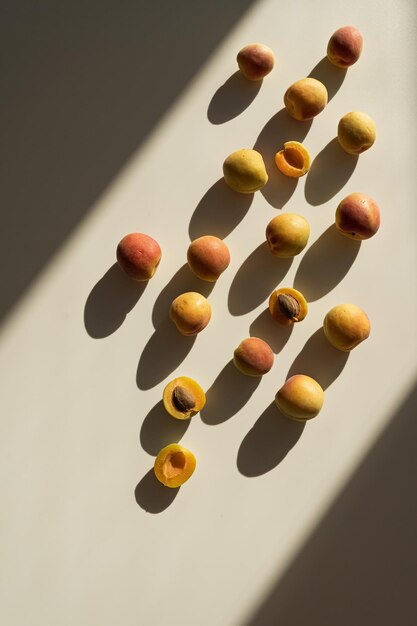 Photo flat lay composition with ripe peaches on neutral beige background with sunlight shadows