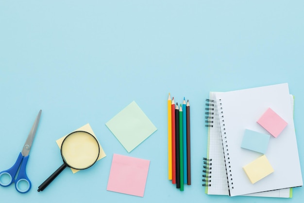 Flat lay composition with school supplies on blue background space for text