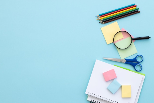 Flat lay composition with school supplies on blue background space for text