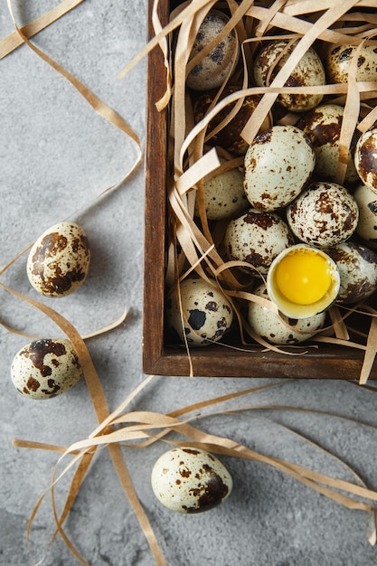 Flat lay composition with small quail eggs in the wooden box on the concrete