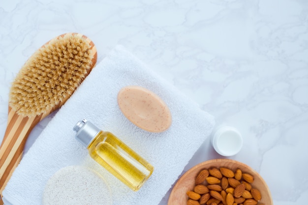 Flat lay composition with spa natural cosmetics almond extract and towel on white background