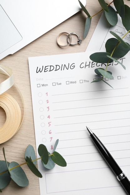 Photo flat lay composition with wedding checklist on white wooden table