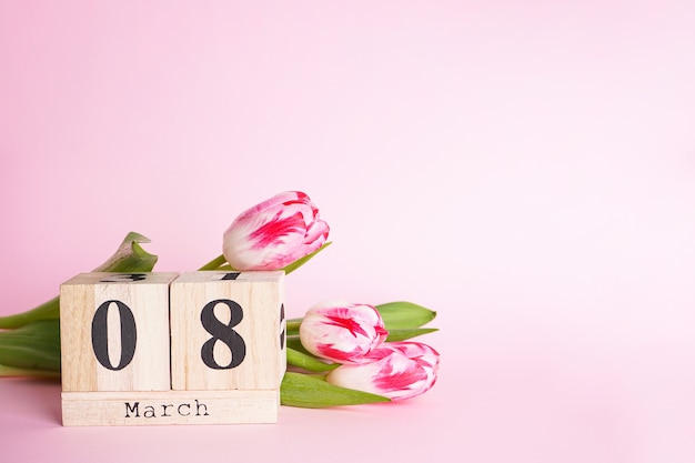 Foto composizione appartamento laica con calendario in legno e tulipani, 8 marzo