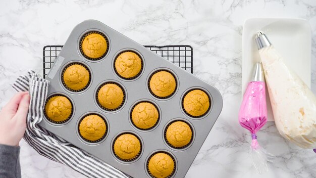 Flat lay. Cooling freshly baked pumpkin spice cupcake.