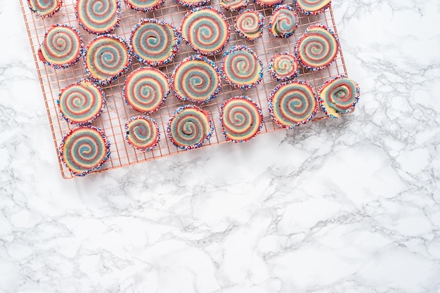 Flat lay. Cooling red, white, and blue pinwheel sugar cookies on a cooling rack.  Dessert for July 4th celebration.