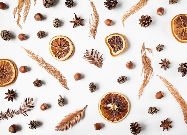 Flat lay creative natural background of winter dry forest plants parts, anise star and dry orange slices